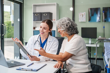 Obraz premium Monthly health check-ups and counseling sessions are provided to an elderly Asian woman by a Caucasian female caregiver, offering support, advice, and motivation.