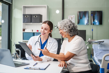 Fototapeta premium Monthly health check-ups and counseling sessions are provided to an elderly Asian woman by a Caucasian female caregiver, offering support, advice, and motivation.