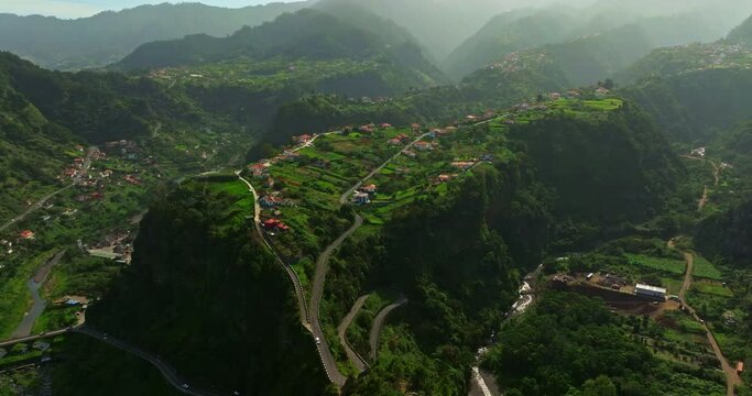 Aerial view over Madeira village located on the tops of green mountains. Portugal