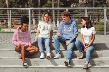 Fototapeta premium Diverse friends in casual apparel, talking on steps