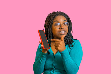 mujer afro usando su telefono movil y mirando al frente mientras usa lentes y señala con su dedo 