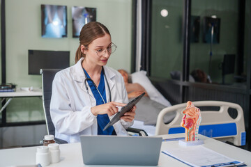 A female Caucasian specialist doctor sits at her desk, specializing in gastrointestinal and liver medicine at the Gastrointestinal and Liver Disease Center.