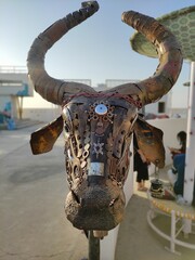 The image showcases an intricate metal bull sculpture adorned with detailing.
