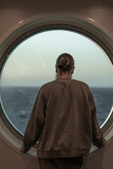 Fototapeta premium man looking out the ship's window