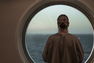 man looking out the ship's window