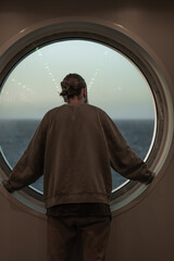 man looking out the ship's window