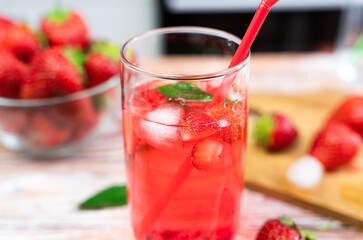 Refreshing lemonade with strawberries, mint and ice cubes. Close-up. Selective focus.