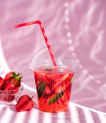 Strawberry lemonade with mint on pink background with beautiful shadows. Close-up. Selective focus.