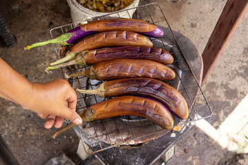 Selective focus purple Eggplant grilled on a charcoal grill - obrazy, fototapety, plakaty