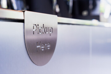Pick Up Here sign on a coffee shop table