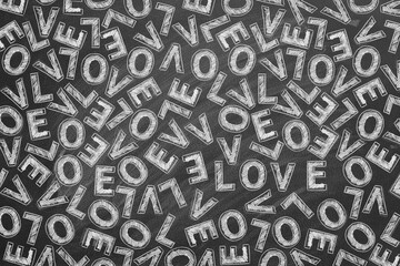 White chalk letters forming the word LOVE repeatedly scattered across a chalkboard.
