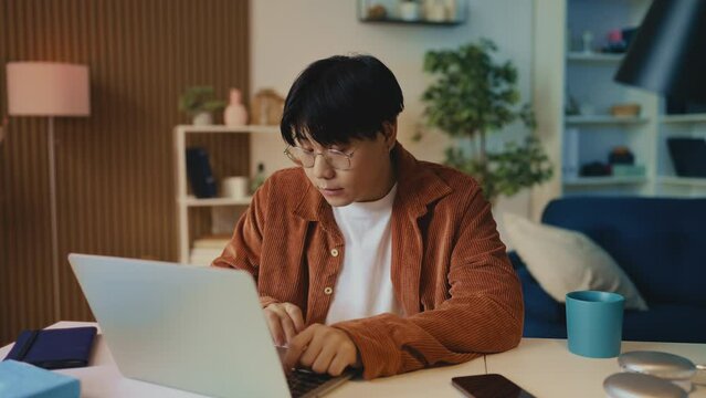 Young male programmer feeling fatigue and eye tension while working on laptop