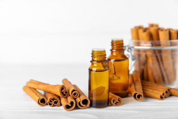 Cinnamon aromatic essential oil and cinnamon sticks on a wooden background. Aromatherapy. Organic cosmetic oil. Spa concept. Place for text. Copy space.