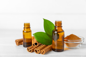 Cinnamon aromatic essential oil and cinnamon sticks on a wooden background. Aromatherapy. Organic cosmetic oil. Spa concept. Place for text. Copy space.