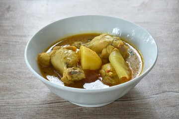 chicken drumsticks massaman curry with slice potato and onion on bowl