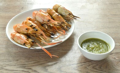 grilled river shrimp arranging on plate dipping spicy Thai seafood sauce 