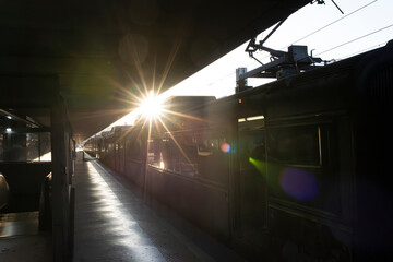 A train is on the tracks with the sun shining on it