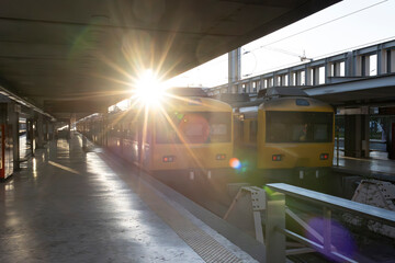 A train station with two yellow trains parked on the platform