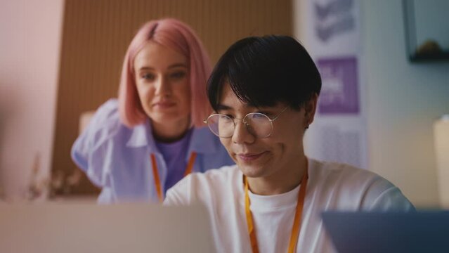 Creative woman teaching a newbie coworker how to promote a social media account