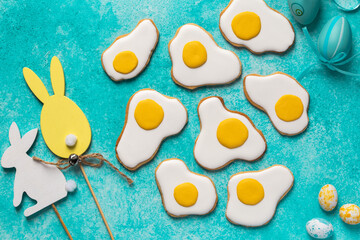 Funny Easter fried eggs icing cookies, sweet food and dessert idea, blue background, top view
