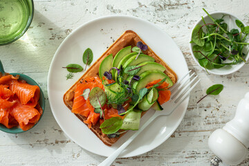  healthy breakfast with smoked salmon, avocado and cucumber waffle sandwich