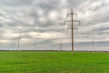 Wind turbines generating electricity in a green field. Green power generation concept.