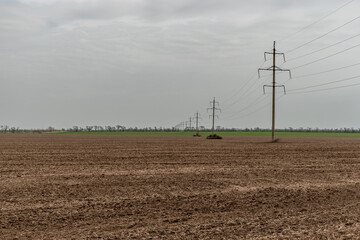 Electricity poles in a field. Electricity power concept.