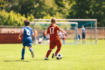 Two Football Soccer Players Running and Kicking a Soccer Ball. School Boys Compete in Soccer League. Two Young Football Players on a Match. Youth European Football Players in Action