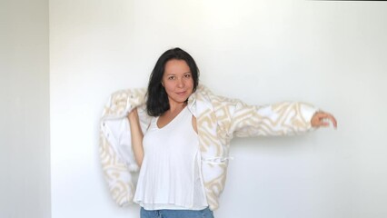 Contemporary chic meets casual comfort; a woman dresses in a light, airy space. Ideal for a modern lifestyle shoot.