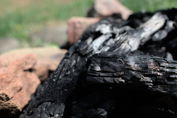 Fototapeta na wymiar Close up of charcoal in a fire pit in a field