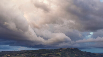 Enorme nuvola bianca sopra il paese in cima alla collina porta la pioggia in una giornata di sole...