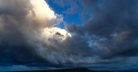 Enorme nuvola bianca e nera sopra il paese in cima alla collina porta la pioggia in una giornata di...