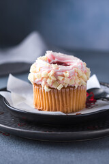 Cupcakes with cream cheese and strawberries. Cupcakes for valentine's day on a concrete table