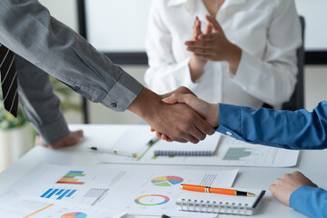 close-up hands image, Professional Asian male and female financial consultant or analyst working with them team, brainstorming and analyzing financial data on the report together in the office