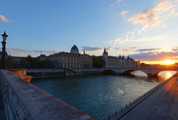 Dramatic sunset over river Seine and Conciergerie in Paris, France, with bridge Pont Neuf....