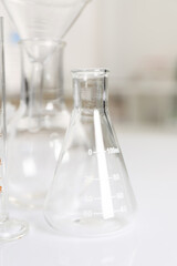 Laboratory analysis. Glass flasks on white table indoors, closeup