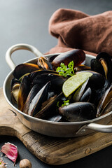 Seafood. Shellfish mussels. Baked mussels on cast iron black plate