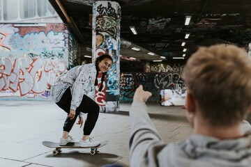 Obraz premium Man recording female skater at skate park