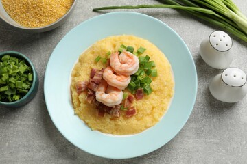 Plate with fresh tasty shrimps, bacon, grits and green onion on grey table, flat lay