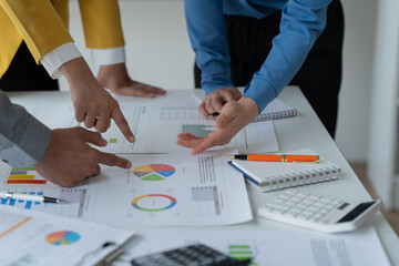 close-up hands image, Professional Asian male and female financial consultant or analyst working with them team, brainstorming and analyzing financial data on the report together in the office