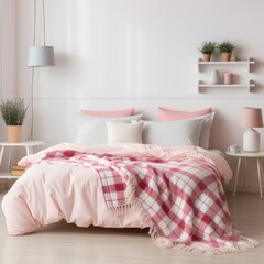 A cozy pink and white bedroom with a plaid blanket