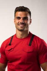 Obraz premium Portrait of a handsome young male firefighter in red uniform smiling