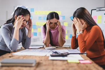 Group of Asian female employees and coworkers in a meeting are stressed in the conference room....