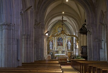Sainte-Mere-Eglise, France - Apr 19, 2024: Sainte-Mere-Eglise church. People walking in...