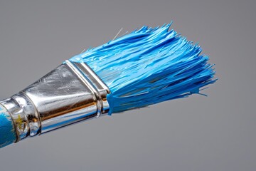 A hyper-realistic image capturing the essence of construction and renovation with a paintbrush coated in vibrant blue paint against a clean, grey background.