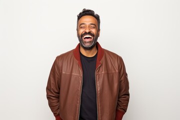 Obraz premium Portrait of a cheerful indian man in his 40s wearing a trendy bomber jacket on white background