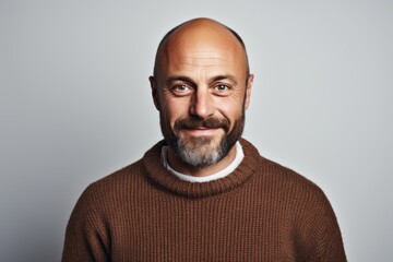 Obraz premium Portrait of a grinning man in his 40s dressed in a warm wool sweater over white background