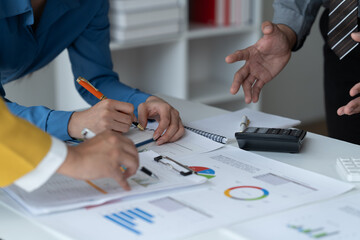 close-up hands image, Professional Asian male and female financial consultant or analyst working with them team, brainstorming and analyzing financial data on the report together in the office