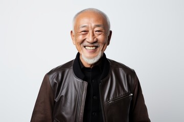 Fototapeta premium Portrait of a grinning asian man in his 60s sporting a stylish varsity jacket on white background