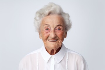 Portrait of a jovial elderly 100 year old woman wearing a classic white shirt over white background